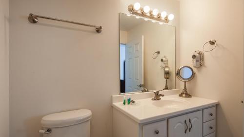ein Badezimmer mit einem WC, einem Waschbecken und einem Spiegel in der Unterkunft Charlevoix Inn & Suites SureStay Collection by Best Western in Charlevoix