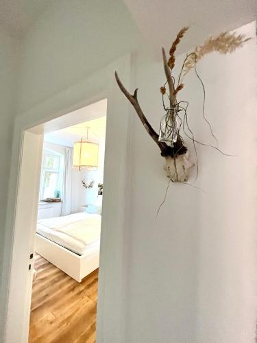 a vase of flowers on the wall of a bedroom at 3 Zimmer Ferienwohnung Burghof mit Balkon im Herzen Flensburgs in Flensburg