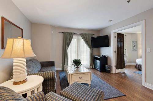 a living room with a couch and a table at Charlevoix Inn & Suites SureStay Collection by Best Western in Charlevoix