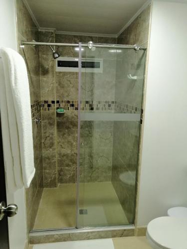 a shower with a glass door in a bathroom at Hostal Raatid Manchy in San Andrés