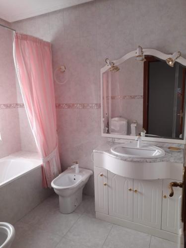 Un baño con lavabo, inodoro y espejo. en Piso en Montillana, en Montillana