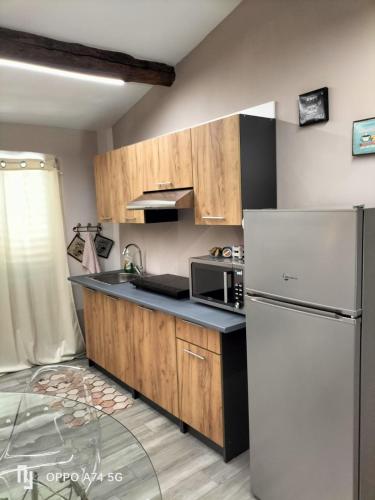 eine Küche mit einem weißen Kühlschrank und einer Mikrowelle in der Unterkunft Chianti wood in Gaiole in Chianti