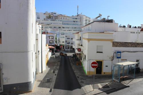 a city street with white buildings and a stop sign at Casa Pérola, Old Town Apartment in Albufeira