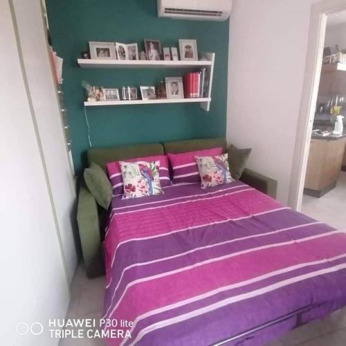 una camera con un letto e una coperta viola di Appartment Carib in Castelbuono a Castelbuono