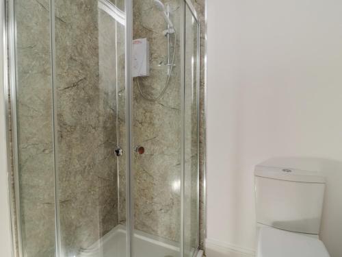 a shower with a glass door next to a toilet at The Dukes Apartments, Flat 3 in Scarborough