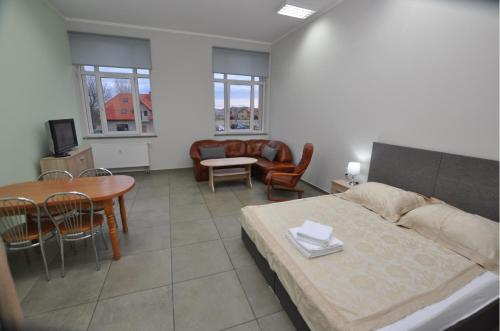 ein Wohnzimmer mit einem Bett, einem Tisch und Stühlen in der Unterkunft Mieszkania Sowiogórskie u podnóża Gór Sowich in Peterswaldau