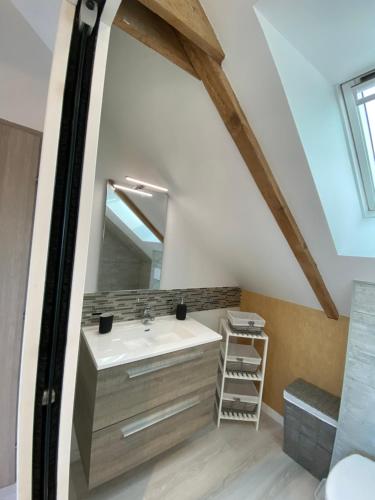 une salle de bain avec un lavabo et un miroir dans l'établissement Chambres d'Hôtes Bella Laïta, à Keranquernat