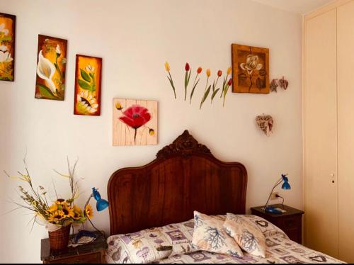 a bedroom with a bed and some pictures on the wall at Casa Viola in Diano Marina
