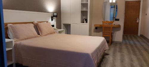 ein Schlafzimmer mit einem großen Bett und einem Schreibtisch in der Unterkunft Hotel Doğa Çeşme in Cesme