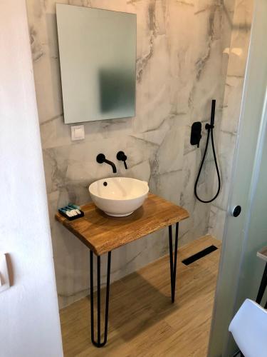 a bathroom with a sink and a mirror on a table at ATHONITE all seasons luxury suites in Ierissos
