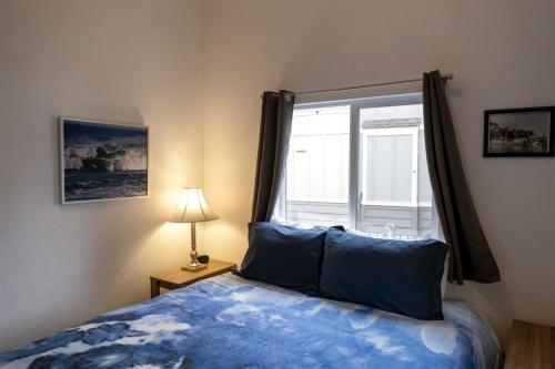een slaapkamer met een blauw bed en een raam bij H - San Juan in Fort Bragg