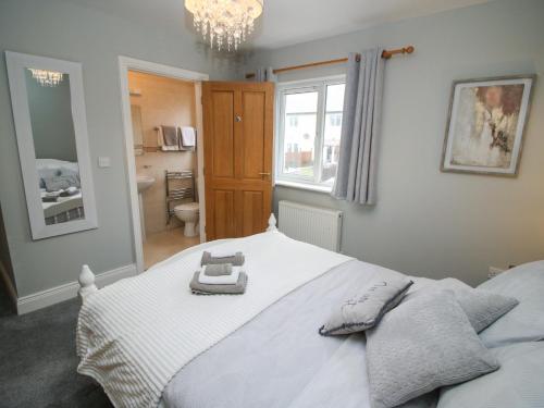 a bedroom with a white bed and a bathroom at Pebble Lodge in Kenmare