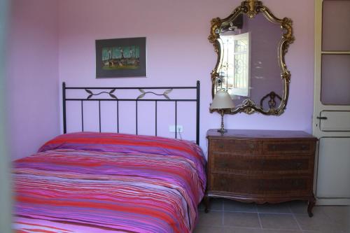 ein Schlafzimmer mit einem Bett und einem Spiegel auf einer Kommode in der Unterkunft MAS GUILLO in San Quintín de Mediona