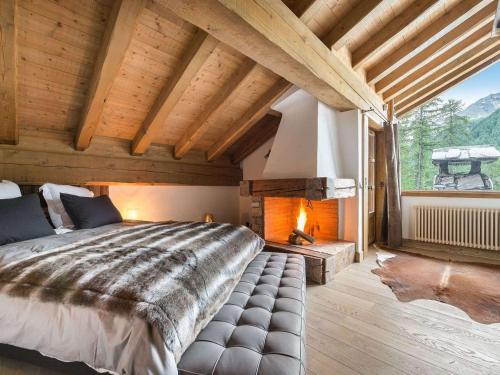 ヴァル・ディゼールにあるChalet de luxe à Val-d'Isère avec accès direct aux pistes, 5 chambres, parking - FR-1-567-64の大きなベッドと暖炉のある寝室