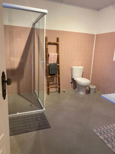 a bathroom with a shower and a toilet at Suite Praia da Feiticeira in Ilhabela