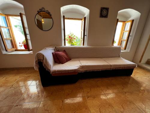 a couch in a room with windows and a mirror at Emilios Traditional Villa in Dhërmi