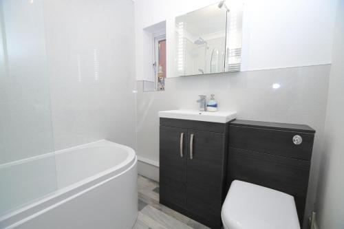 y baño con aseo, lavabo y espejo. en Exmouth - Newly available, near the Beach, en Exmouth