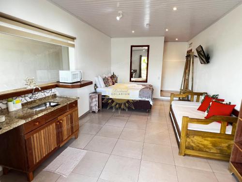 a bathroom with a sink and a bed in a room at Residencial Solariun Ilhabela in Ilhabela