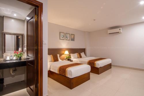 a hotel room with two beds and a bathroom at Galaxy Airport Hotel in Ho Chi Minh City