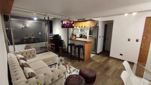 un soggiorno con divano bianco e una cucina di Rocky House - Hostal Boutique Providencia a Santiago