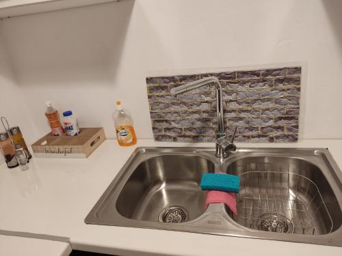 a kitchen sink with a blue sponge in it at CORFU OASIS studio in Neochorákion