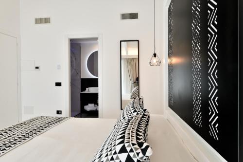een slaapkamer met een bed en zwart-wit meubilair bij Cara a Bentu - Charming Rooms in Tortolì