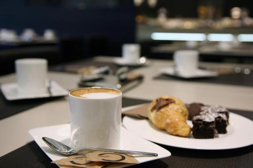 a plate with a cup of coffee and a pastry at Ego Hotel in Ancona
