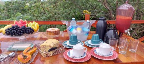 uma mesa de madeira com comida e bebidas em Cabanas Bouganville em Monte das Gameleiras