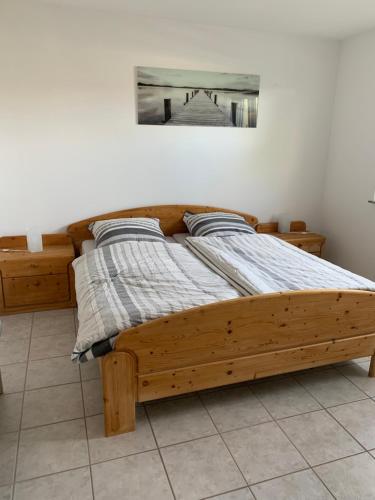 een houten bed in een slaapkamer met een foto aan de muur bij An den Weinbergen in Güntersleben