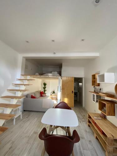 una sala de estar con una escalera que conduce a un dormitorio en 7 Trevos Houses A, en Santiago do Cacém