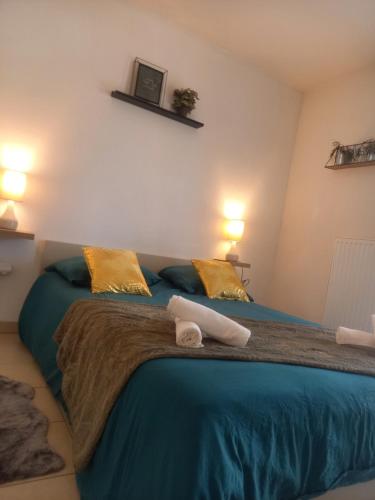 - une chambre dotée d'un grand lit avec des draps bleus et des oreillers jaunes dans l'établissement Cocon reposant à 10min du centre de Bordeaux, à Lormont