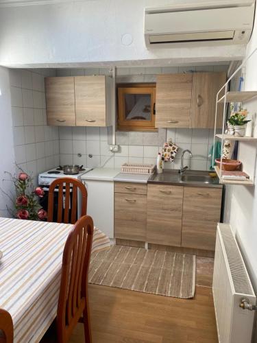 eine kleine Küche mit Holzschränken und einem Tisch in der Unterkunft Pansion Vlado in Međugorje