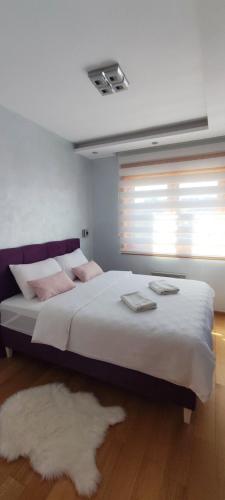 a bedroom with a large bed with a window at Vila Pino Silvestre in Zlatibor