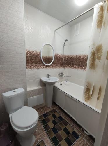 ein Badezimmer mit einem WC, einem Waschbecken und einer Badewanne in der Unterkunft Уютная квартира in Oral