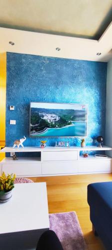 a living room with a large tv on a blue wall at Vila Pino Silvestre in Zlatibor