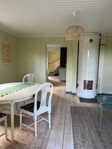 una sala da pranzo con tavolo e sedie bianchi di Charlottenborg a Söderköping