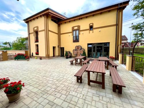 a patio with wooden benches and a building at Vila Liberta in Poprad