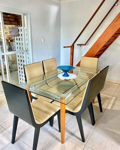 a dining room table with chairs and a blue bowl on it at Double Deck - Linda vista com Jacuzzi in Palhoça