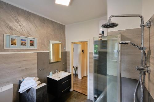 a bathroom with a shower and a sink and a glass shower stall at Ferienwohnung Mitten im Pott in Bottrop