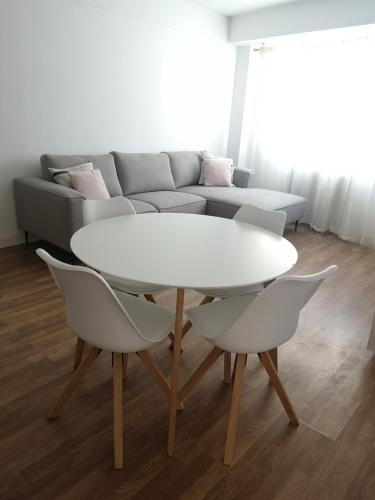uma mesa branca e cadeiras numa sala de estar com um sofá em Apartamento Castelo de Santa Cruz em Oleiros
