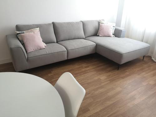 a living room with a gray couch and pink pillows at Apartamento Castelo de Santa Cruz in Oleiros