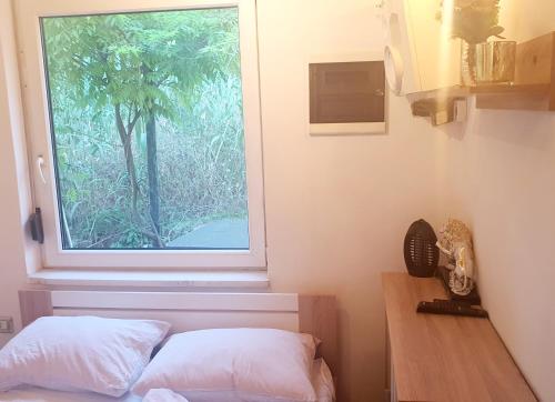 a bedroom with a window and a bed and a desk at Little Brioni in Sečovlje