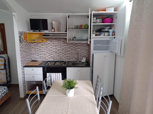 uma pequena cozinha com uma mesa e um frigorífico em oasi macerina em Alanno