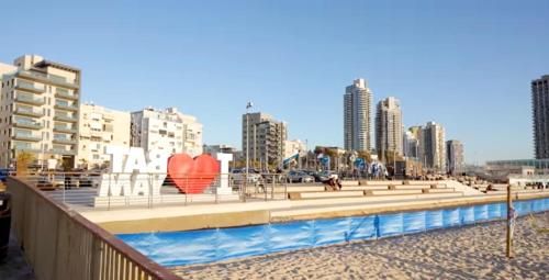 una playa con una fuente con una escultura cardíaca en Hotel Apartment Short Term Tel Aviv Bat Yam 353, en Bat Yam