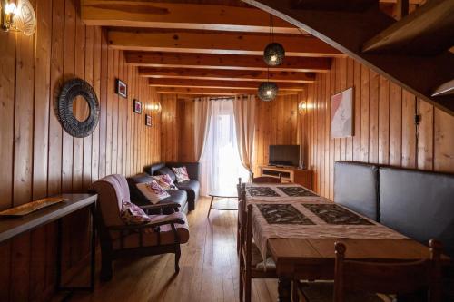 ein Wohnzimmer mit einem Sofa und einem Tisch in einem Zimmer in der Unterkunft La Cabane du Petit Tour in Langogne