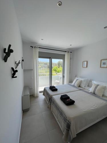 a bedroom with a large bed and a large window at Villa Lemoni in Kamilari