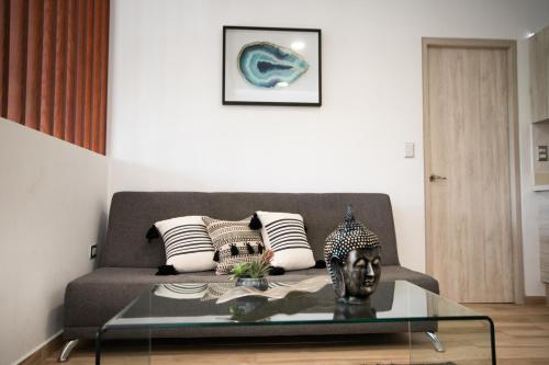 a living room with a couch and a glass table at Macondo Quinta Avenida Residences in Playa del Carmen