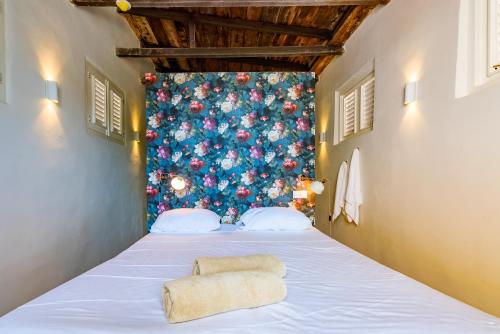 - un lit dans un dortoir avec un mur fleuri dans l'établissement Wynwood Boutique Hotel, à Willemstad