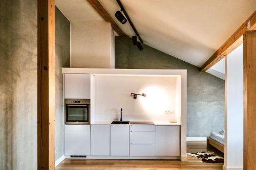 a kitchen with white cabinets and a sink at Boutique REZIDENCE BAAR in Nový Jičín