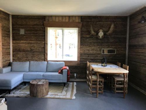 Cozy Stuga - Mountain View في Ramsele: غرفة معيشة مع أريكة وطاولة